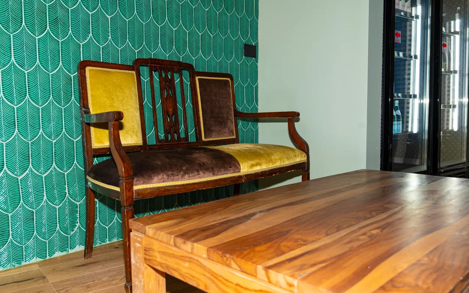 Angolo di Duilio con parete in piastrelle verdi, panca d'epoca e tavolo in legno massello